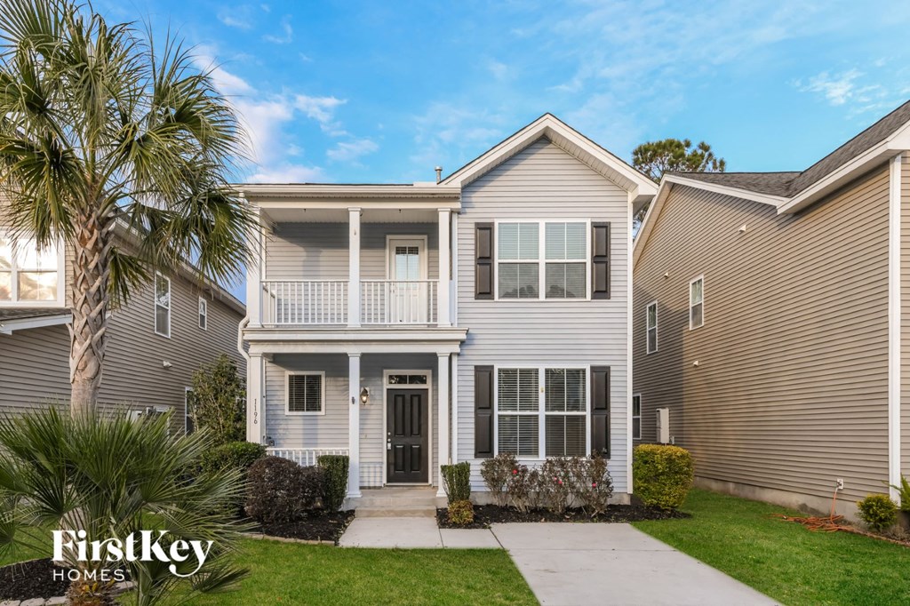 a white house with a palm tree in front of it