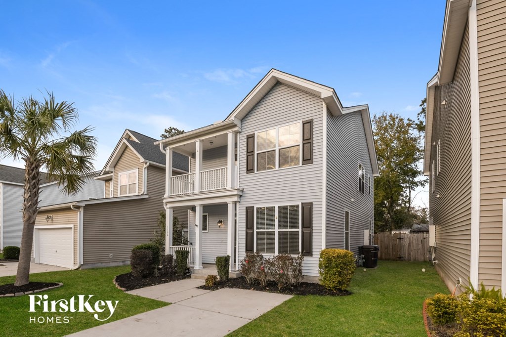 a with a white porch and a palm tree