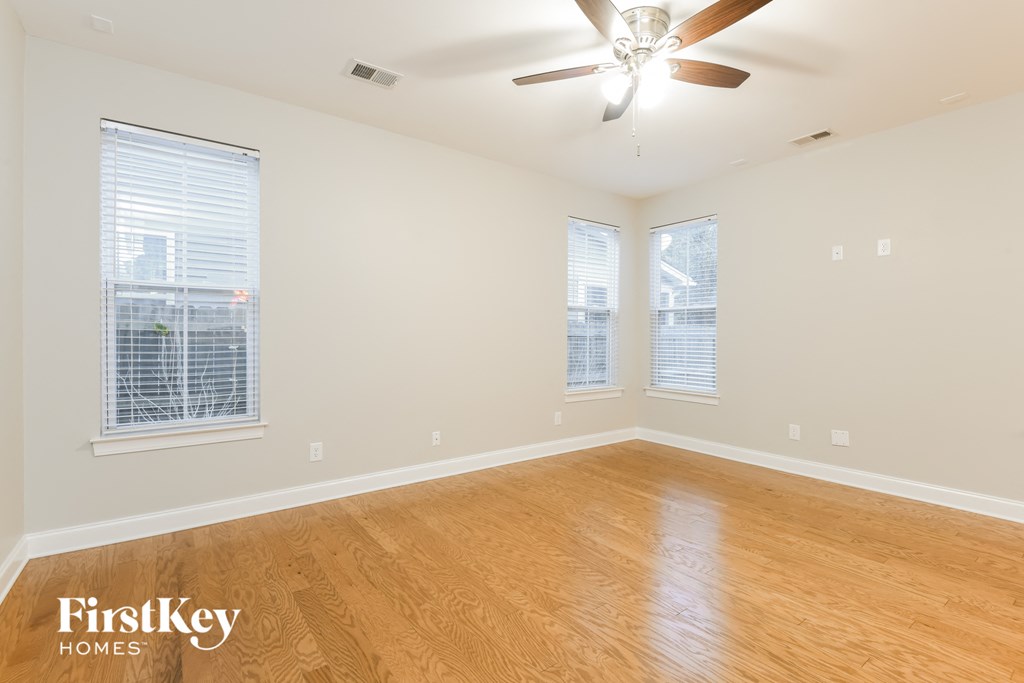 a living room with wood floors and a ceiling fan