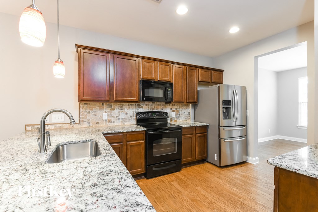 a kitchen with granite counter tops and wooden cabinets and stainless steel appliances