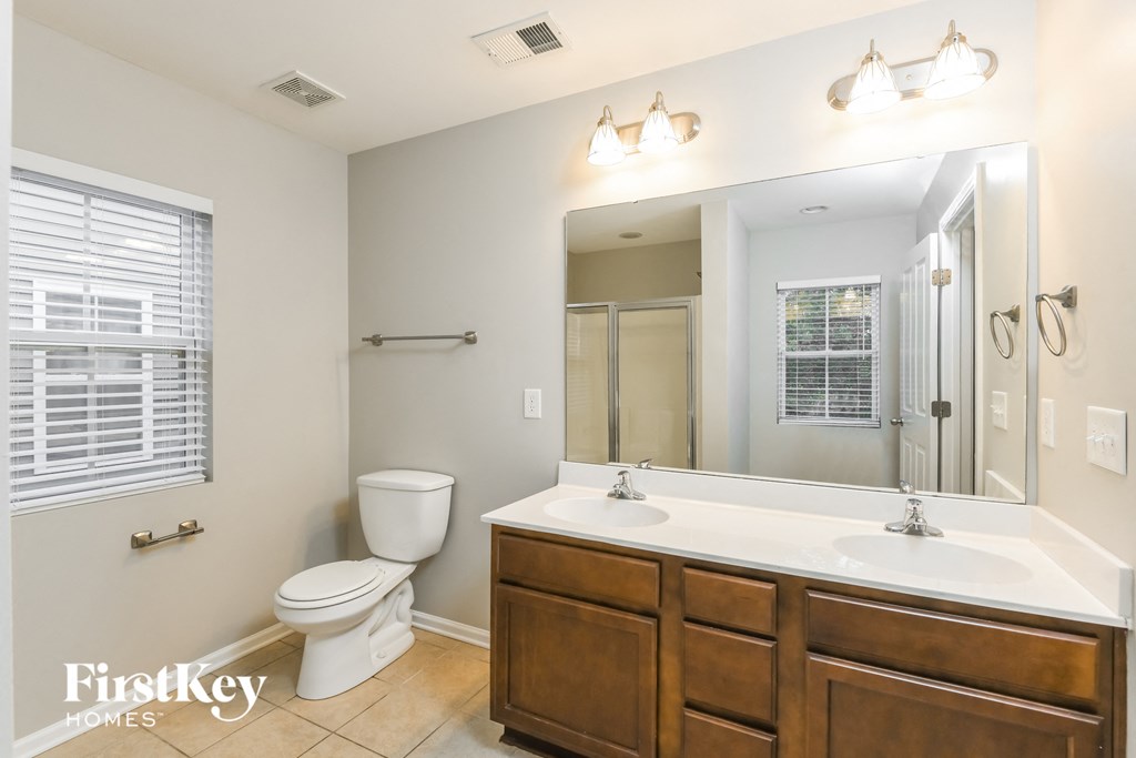 a bathroom with a large mirror and a toilet and a sink