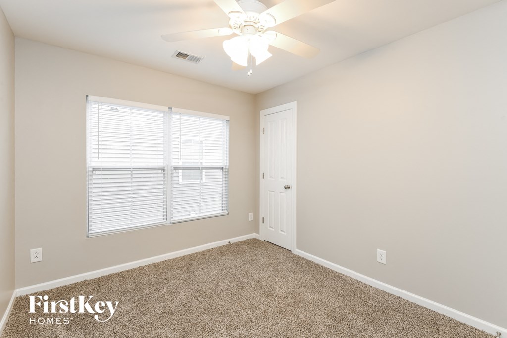 a bedroom with a ceiling fan and a window