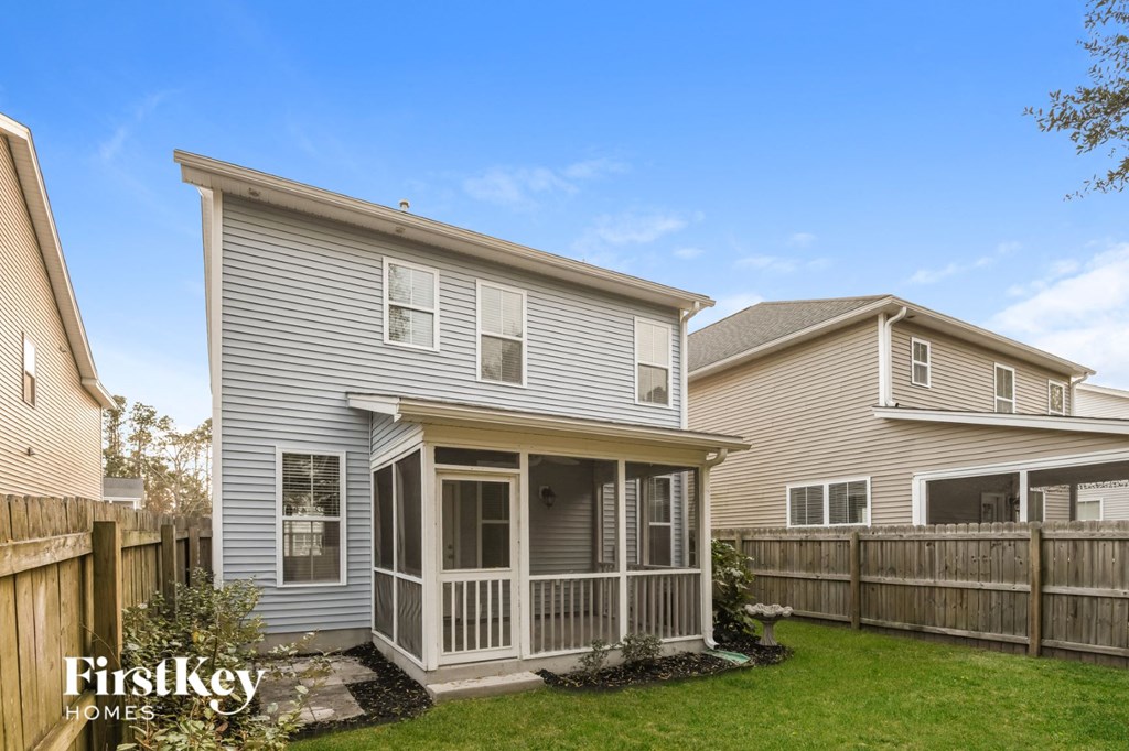 a white house with a porch and a wooden fence