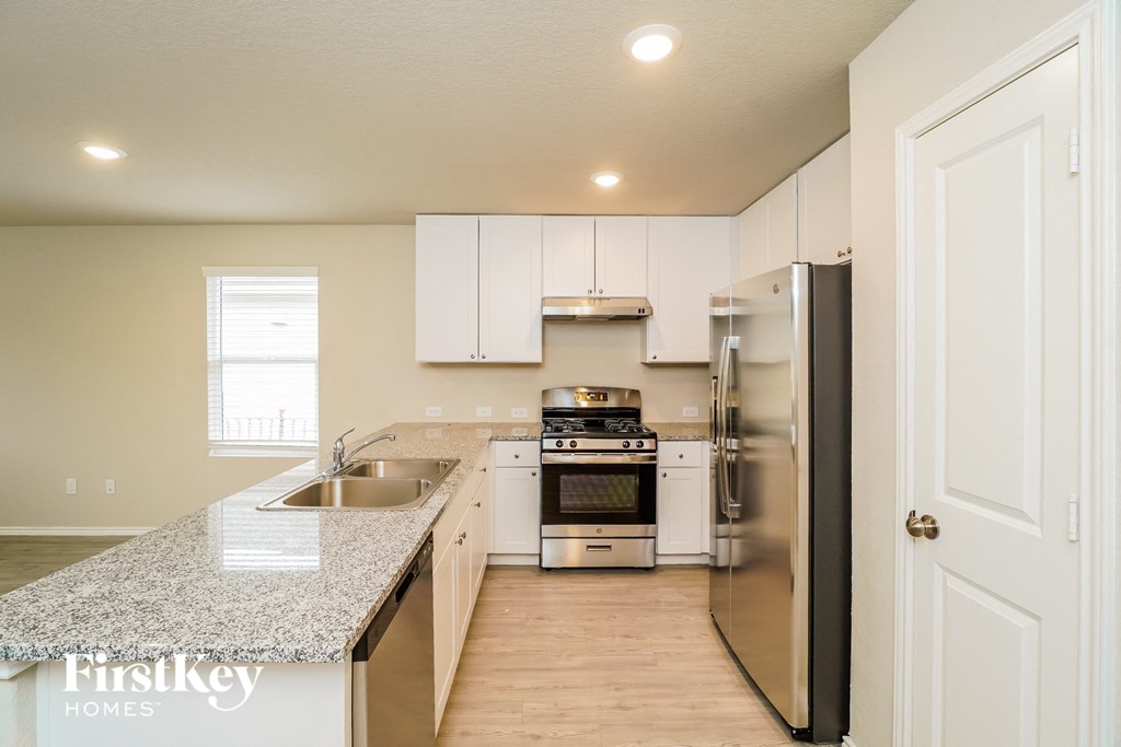 A kitchen with granite countertops and stainless steel appliances.
