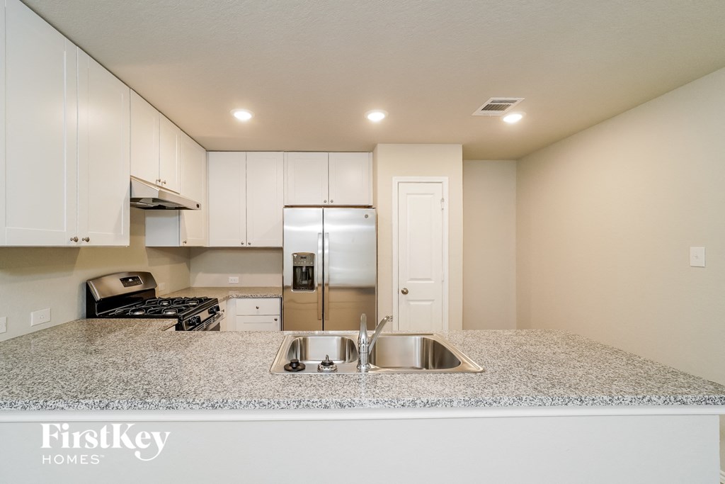 A kitchen with granite countertops and stainless steel appliances.