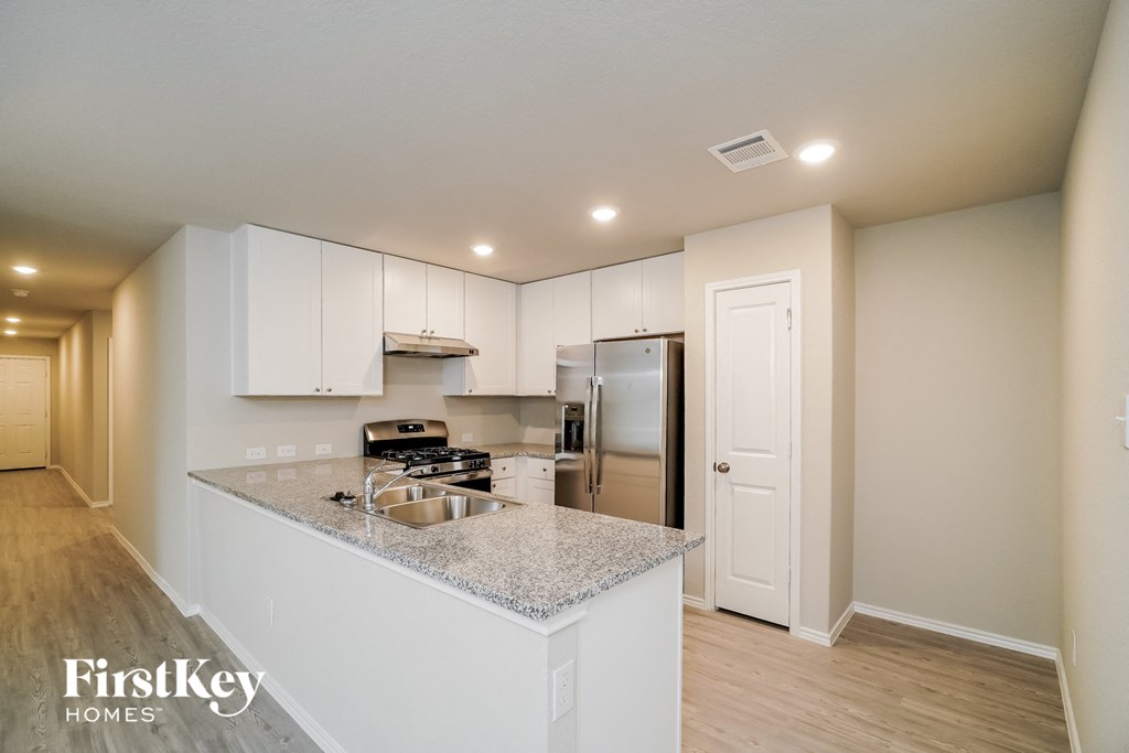 A kitchen with a granite countertop and stainless steel appliances.