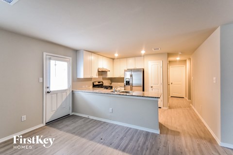 A kitchen area with a counter and cabinets is shown in a well-lit room.