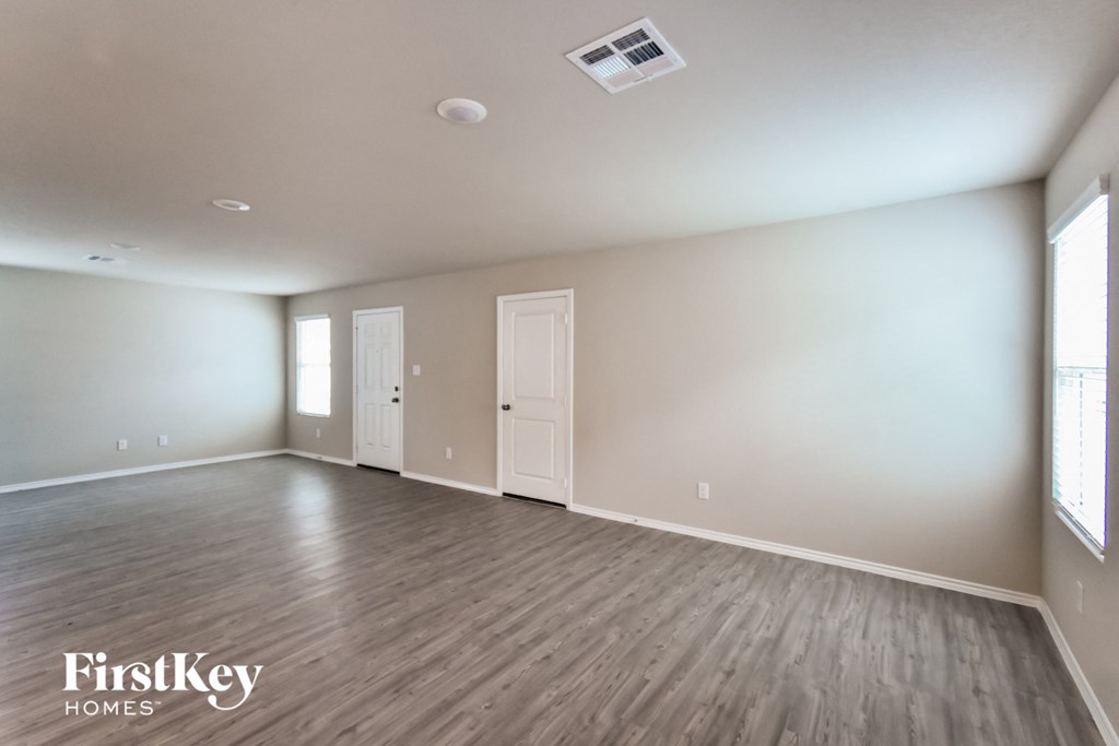 A spacious room with wooden flooring and a FirstKey Homes logo.