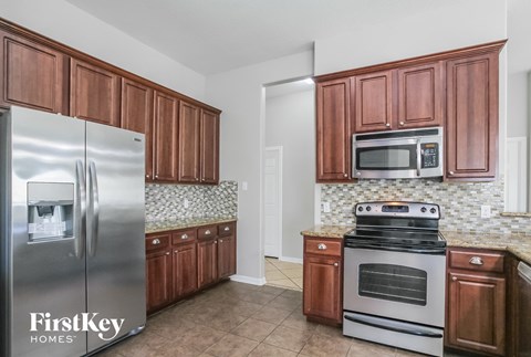A kitchen with wooden cabinets and a stainless steel refrigerator.