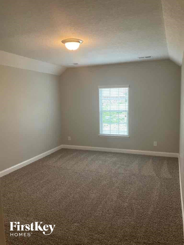 an empty room with carpet and a window