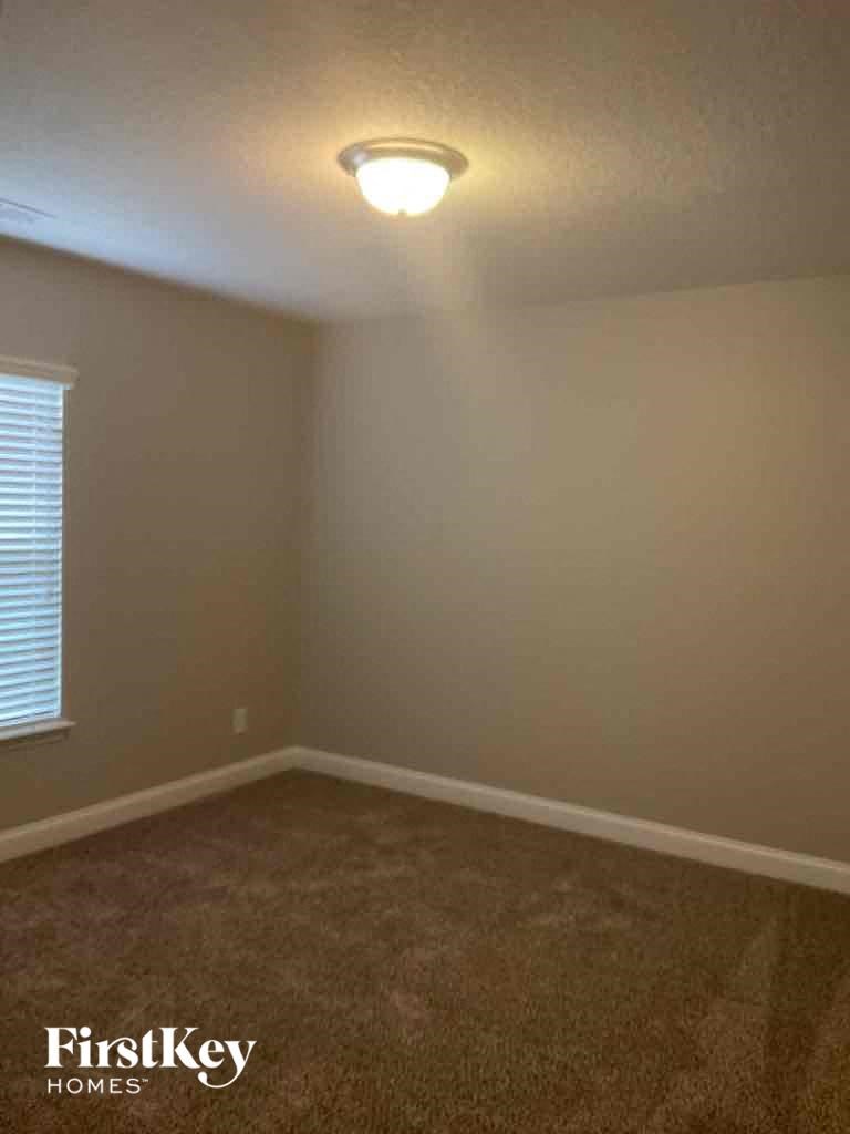 an empty room with a lamp on the ceiling