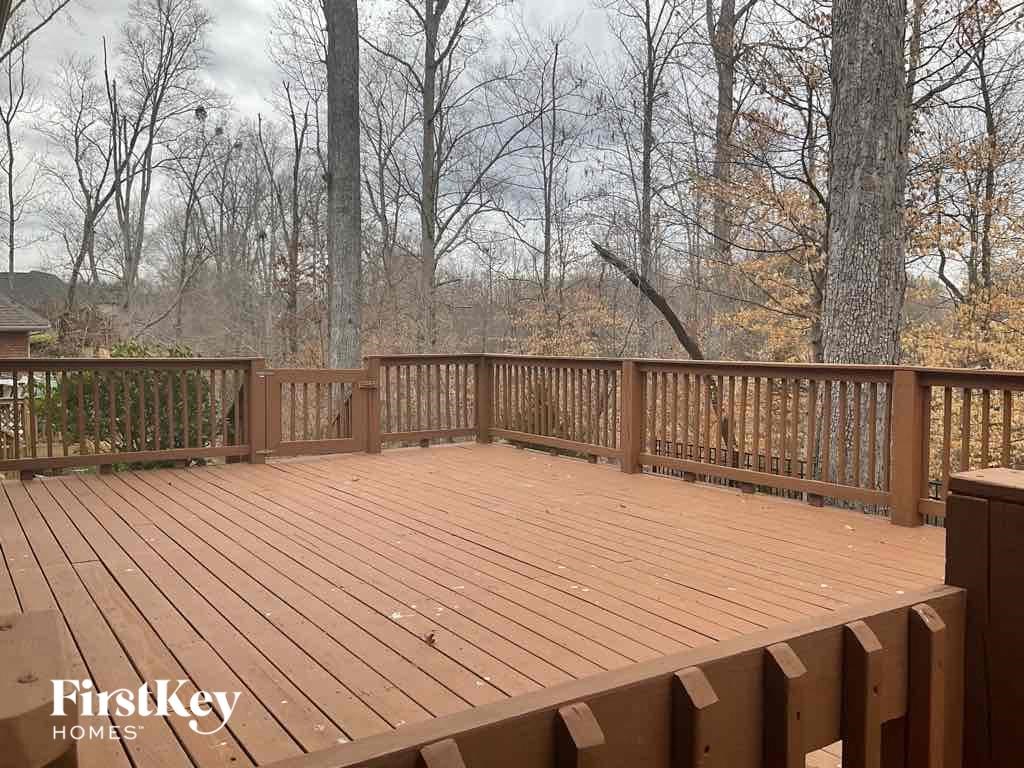 the deck of a cabin with a view of the woods