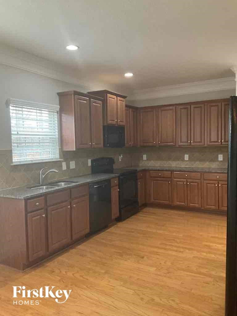 an empty kitchen with wooden floors and wooden cabinets