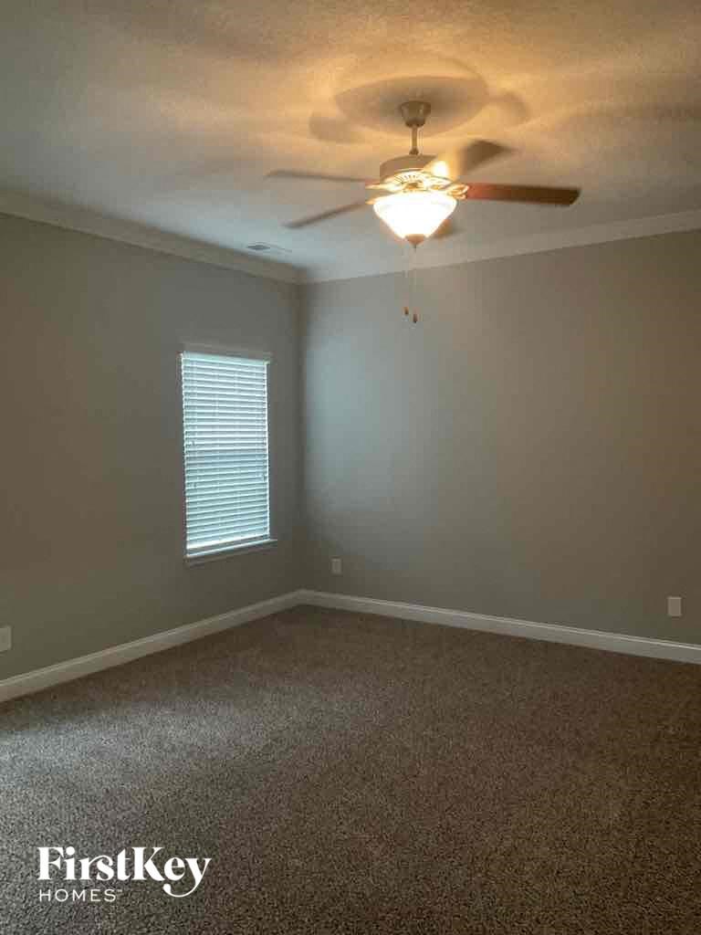 an empty room with a ceiling fan and a light