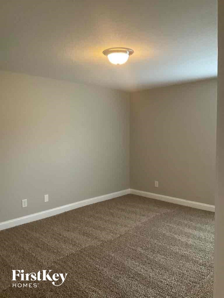 an empty room with carpet and a light on the ceiling