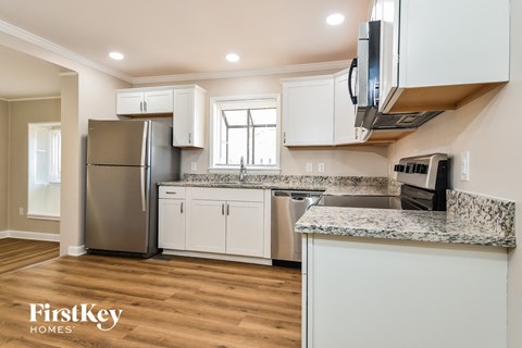 a kitchen with white cabinets and stainless steel appliances