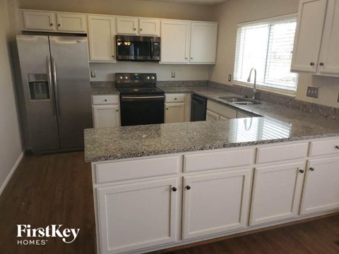 a kitchen with white cabinets and granite counter tops