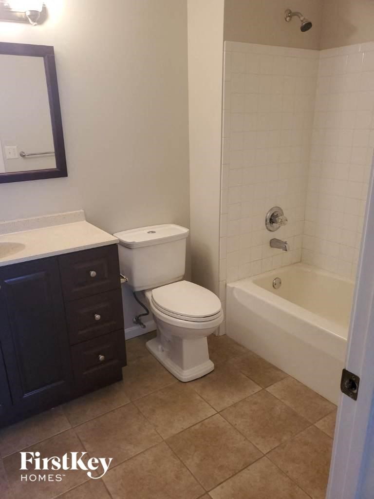 a bathroom with a toilet and a tub and a sink