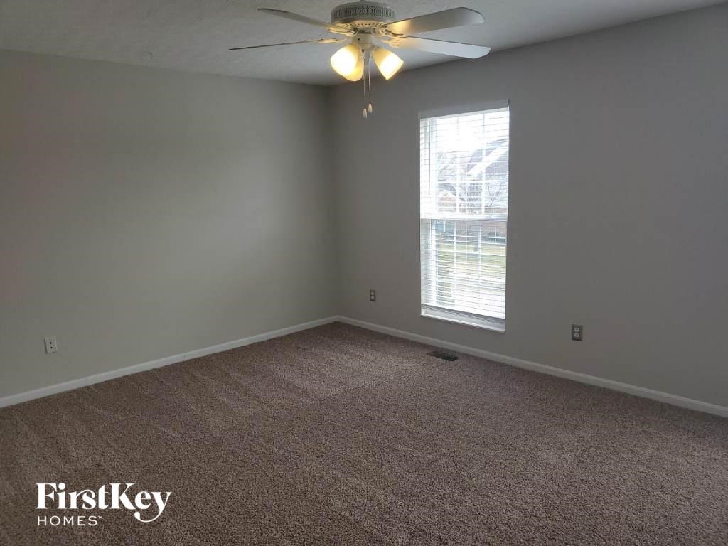 a bedroom with a ceiling fan and a window