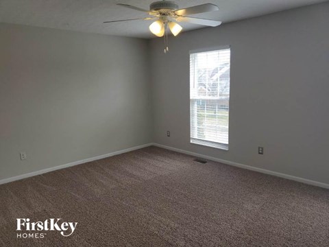 a bedroom with a ceiling fan and a window
