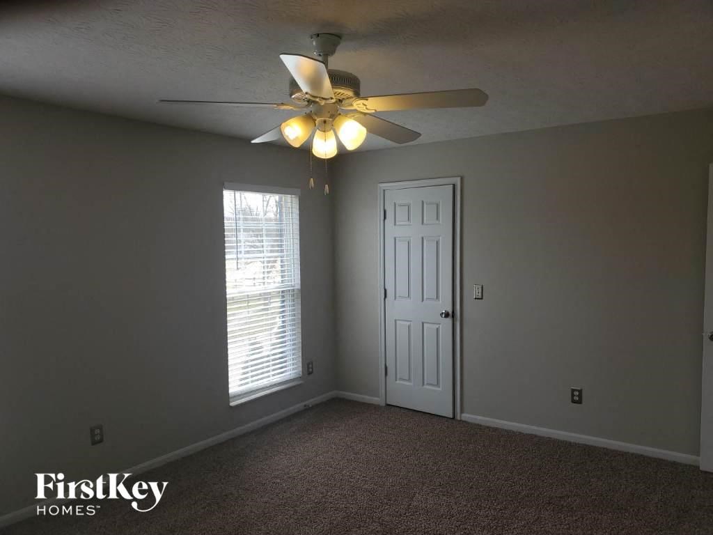 a bedroom with a ceiling fan and a door