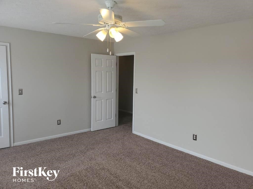a bedroom with a ceiling fan and a door to a closet