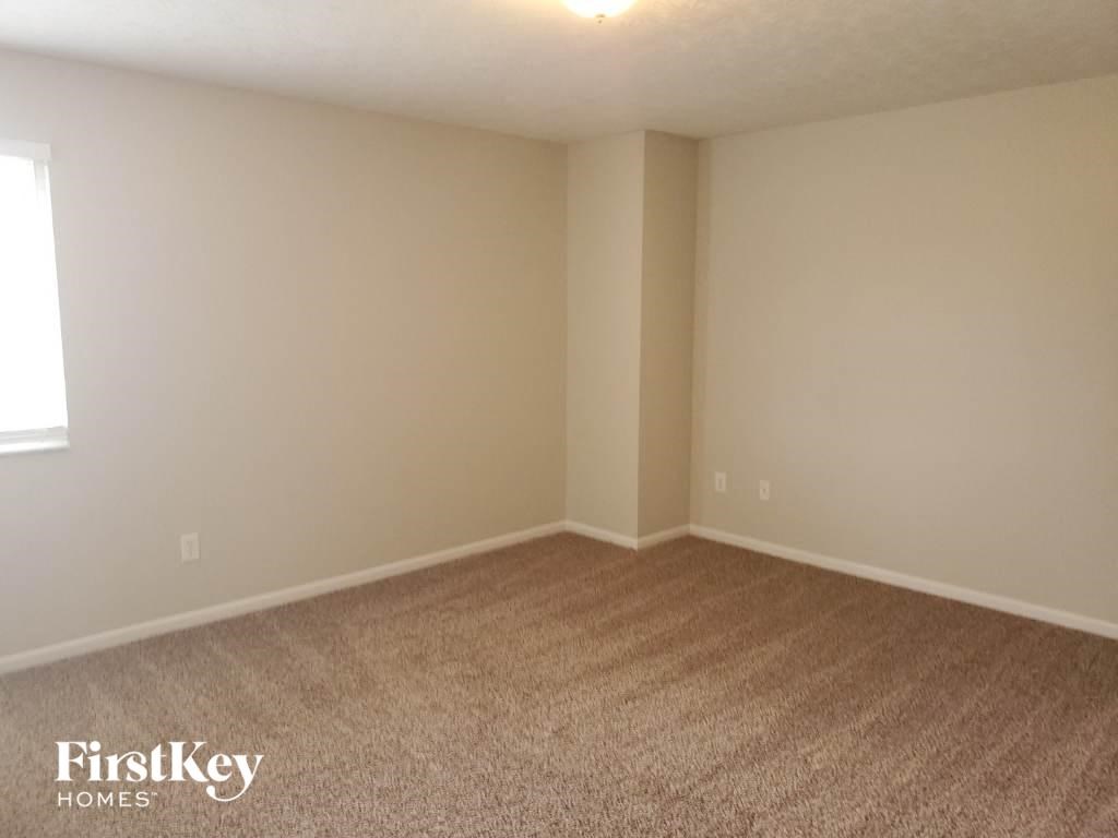 a empty room with carpet and a window