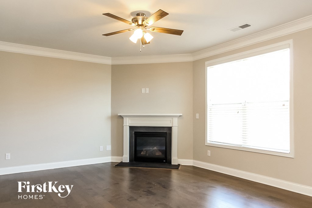 a living room with a fireplace and a ceiling fan