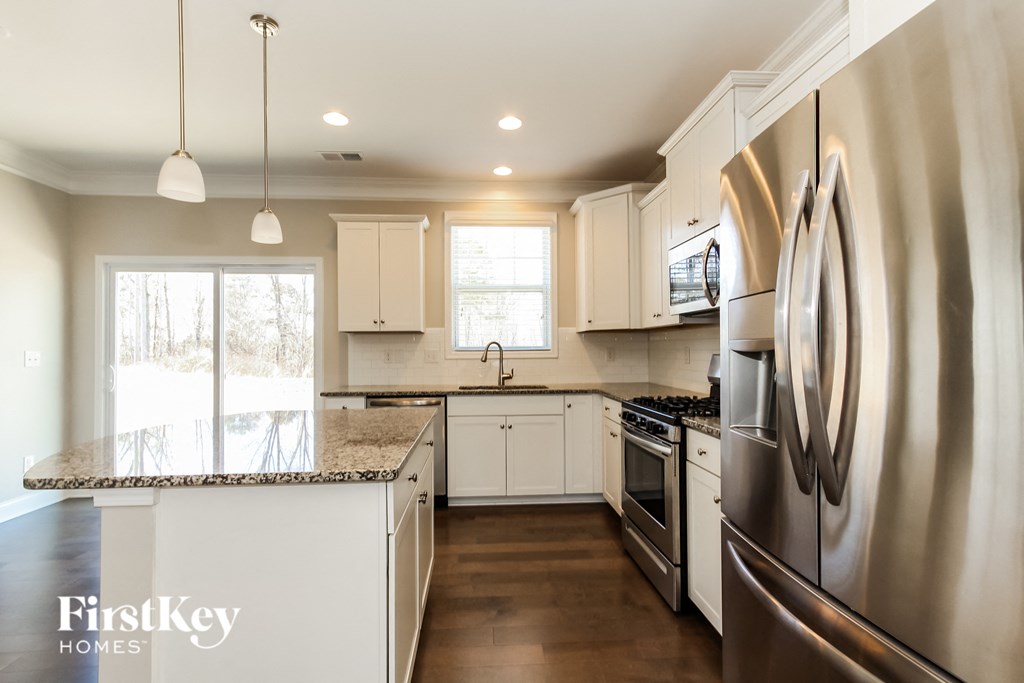 a kitchen with white cabinets and stainless steel appliances