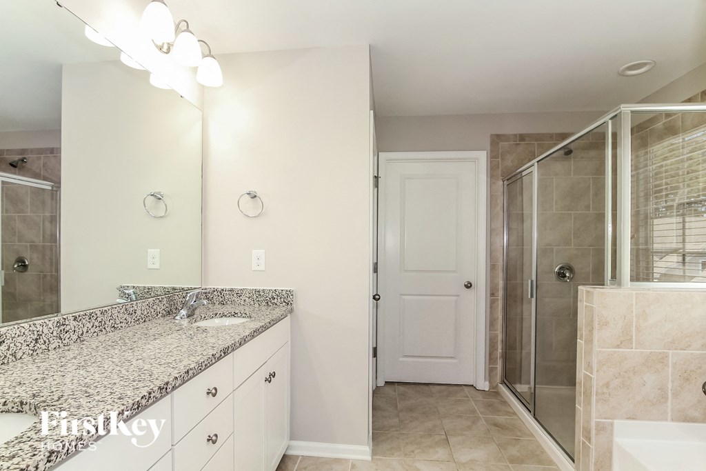 a bathroom with granite counter tops and a shower