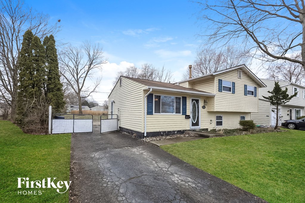 A house with a driveway and a car parked in front.