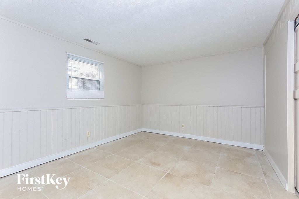 A room with a window and a tiled floor.