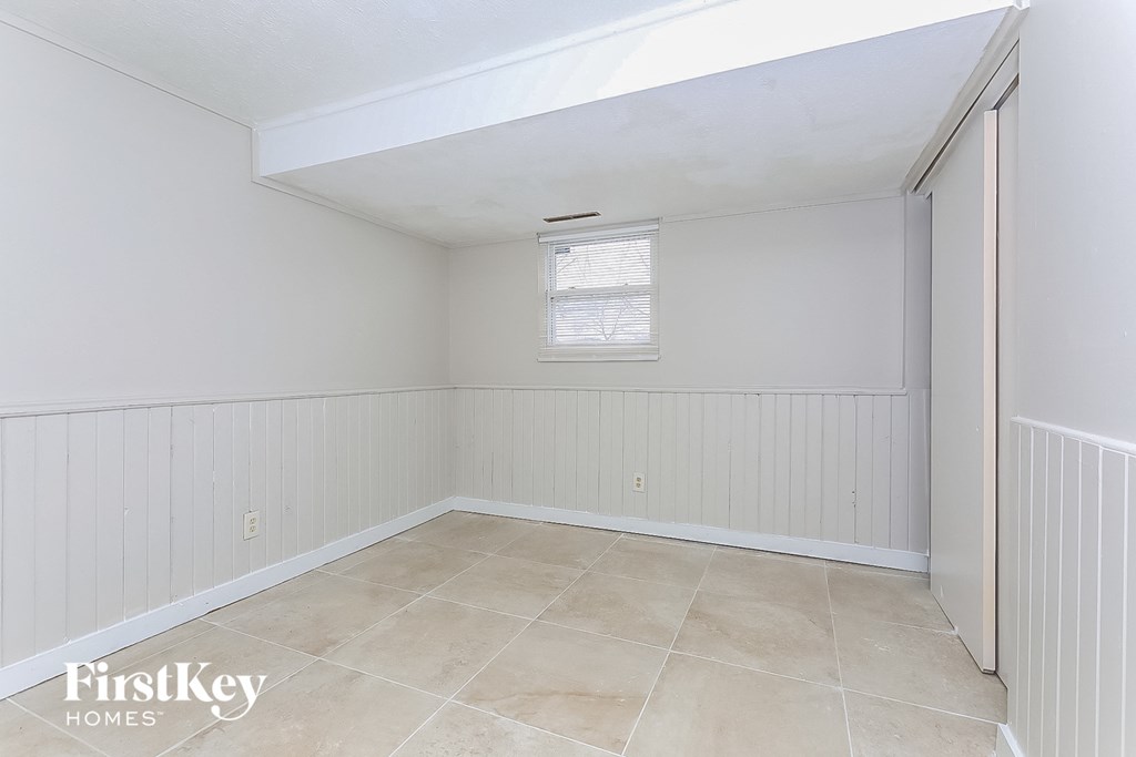 A room with a window and a tiled floor.
