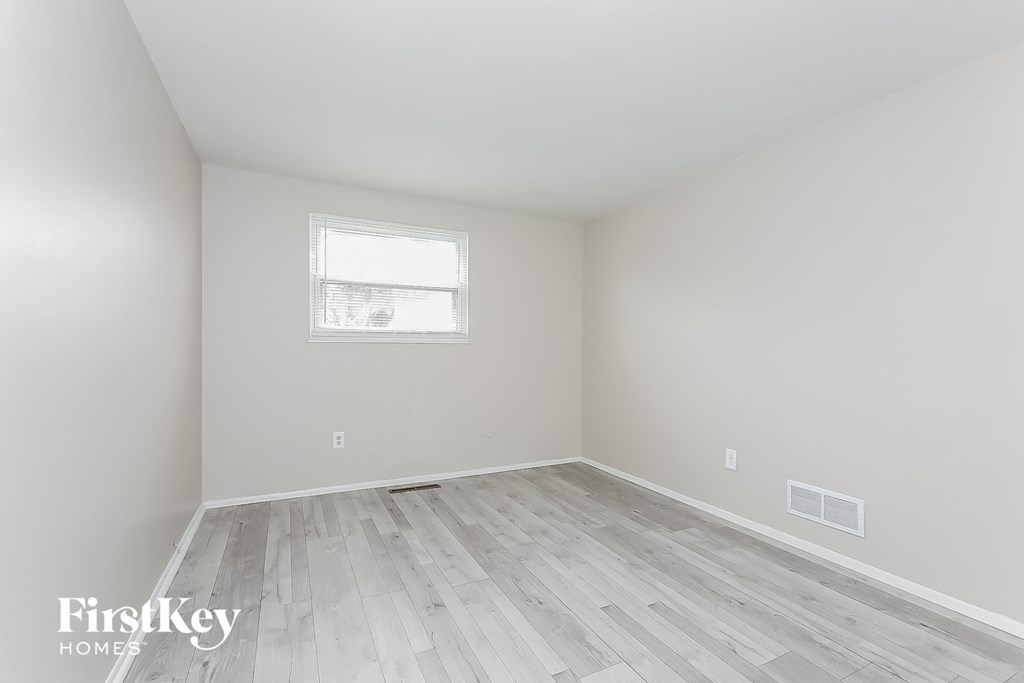 A room with a wooden floor and a window.