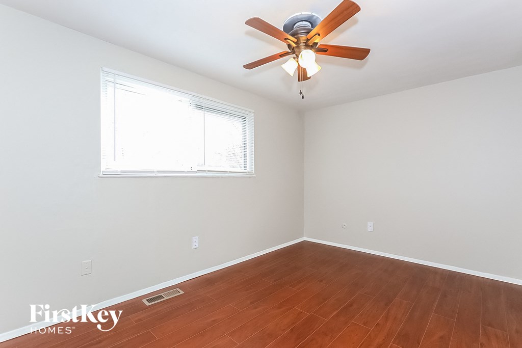 A room with a ceiling fan and a window.