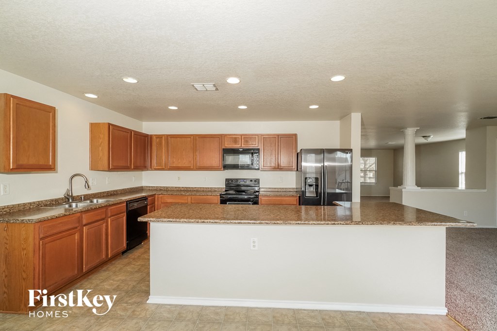 a kitchen with a large island and wooden cabinets