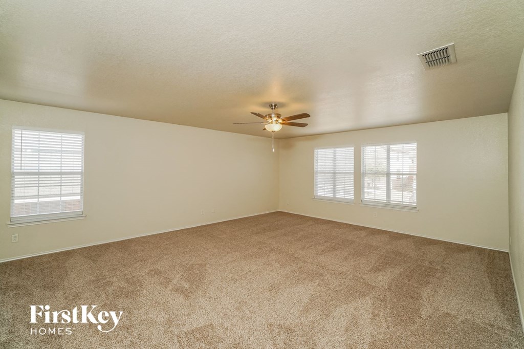 a living room with carpet and a ceiling fan