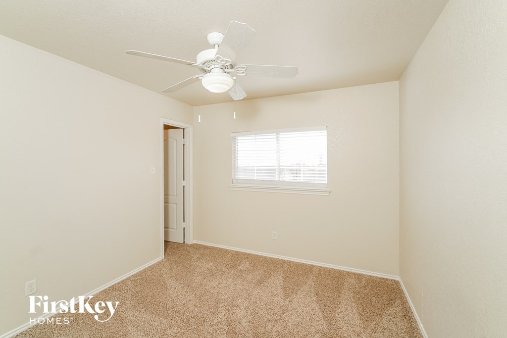 a bedroom with carpet and a ceiling fan