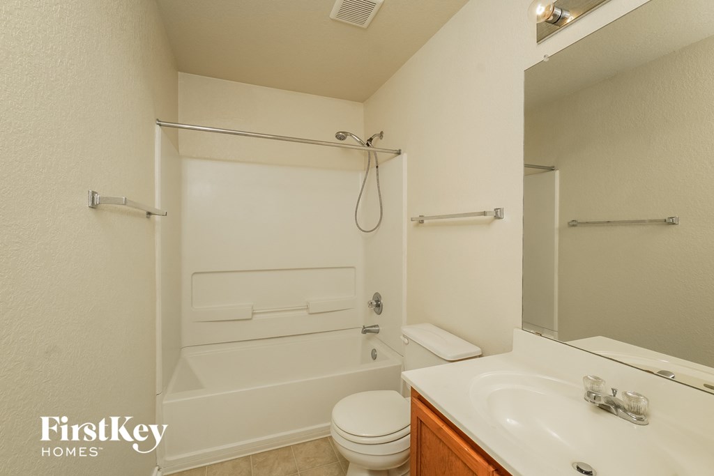 a bathroom with a shower toilet and sink and a mirror