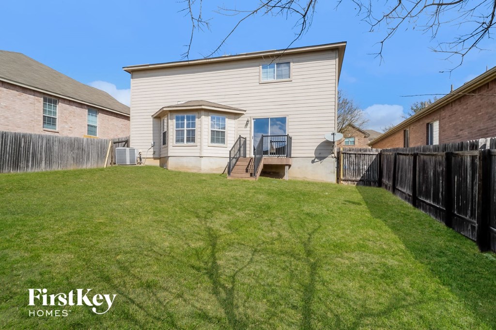 the back of a house with a yard and a fence