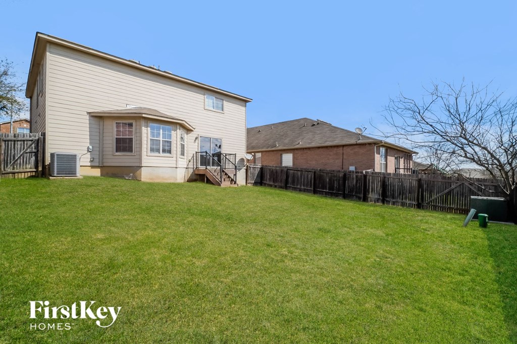 the backyard of a house with a yard and a fence