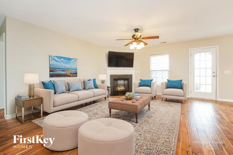 A well-lit living room with a fireplace and a painting on the wall.