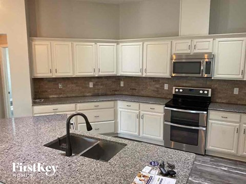 a kitchen with white cabinets and a sink
