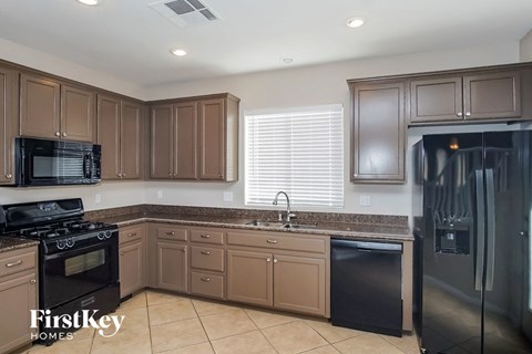 A kitchen with brown cabinets and black appliances.