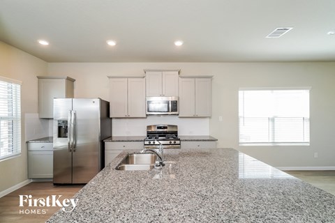 A kitchen with granite countertops and stainless steel appliances.