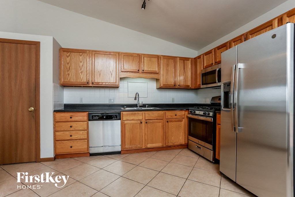 a kitchen with wooden cabinets and stainless steel appliances