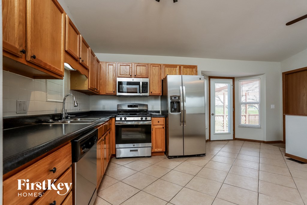 a kitchen with wooden cabinets and stainless steel appliances