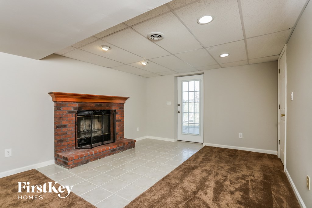 the living room with fireplace and tile flooring
