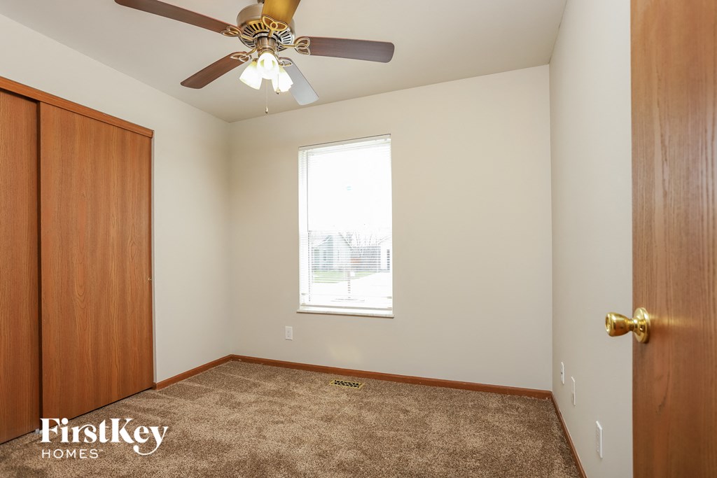 a bedroom with a ceiling fan and a window