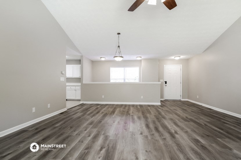 the spacious living room and kitchen of an apartment